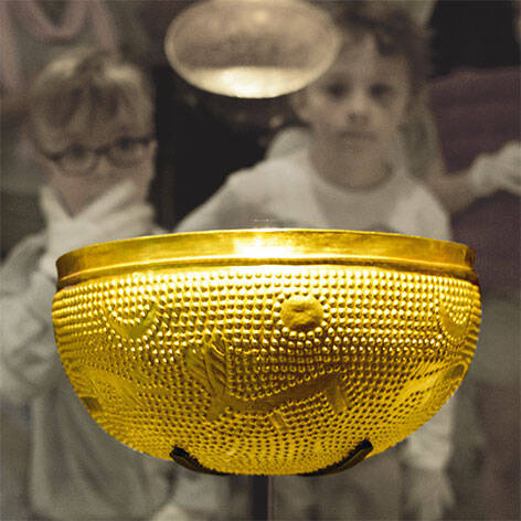 Kinder betrachten die Goldschale in der Ausstellung "Archäologie"