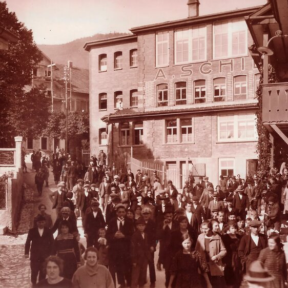 Uhrenarbeiterinnen und Uhrenarbeiter der A. Schild SA (Assa) verlassen nach Feierabend die Fabrik. Foto aus dem Jahr 1924.
