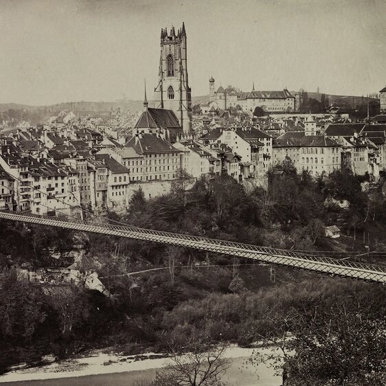 Freiburg um 1900. In der Mitte die Stiftskirche St. Nikolaus und Staatskanzlei, im Vordergrund die Grand Pont suspendu.