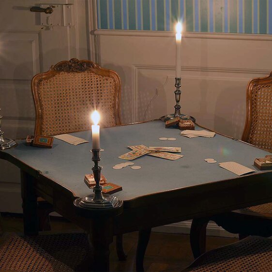 The elite of Solothurn society gathered at tables like this one for card game evenings. This table belonged to the Glutz family, and the candlesticks belonged to the Greder-von Stäffis family. The playing cards and token boxes made of leather-covered cardboard are part of a Tarock set in book form dating from 1778.