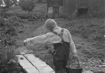 Bis 1981 nehmen Behörden ohne Gerichtsverfahren Hunderttausende Kinder ihren Familien weg. Die Behörden verdingen Kinder auf Bauernhöfe als billige Arbeitskräfte oder platzieren sie in Heimen, geschlossenen Einrichtungen sowie Strafanstalten. Oft müssen sie dort Zwangsarbeit leisten. Viele werden sexuell ausgebeutet. Sie leiden bis heute unter den Folgen der körperlichen und psychischen Gewalt. Wasser holen an der Quelle, 1947, Unteriberg, Foto Theo Frey, Schwyz. | © © Theo Frey Archiv / Fotostiftung Schweiz, Winterthur