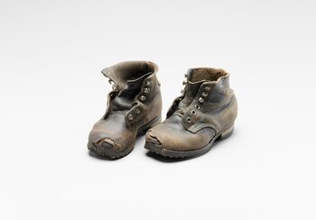 Zwischen 1801 und 1914 treibt die Armut jedes Jahr Jungen und Mädchen aus Graubünden und der Ostschweiz nach Oberschwaben. Dort arbeiten die Kinder gegen Kost und Logis und für einen bescheidenen Lohn von April bis Oktober bei den Bauern. Die Knaben hüten Vieh, die Mädchen helfen im Haushalt oder betreuen kleine Kinder. Halbhohe Kinderschuhe mit Ösen und Haken, 1900 – 1925, Rindsleder | © © Schweizerisches Nationalmuseum