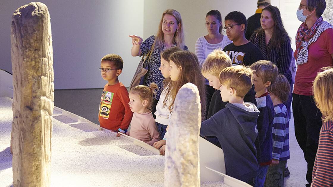 Familien auf einer Führung in der Wechselausstellung "Menschen. In Stein gemeisselt"