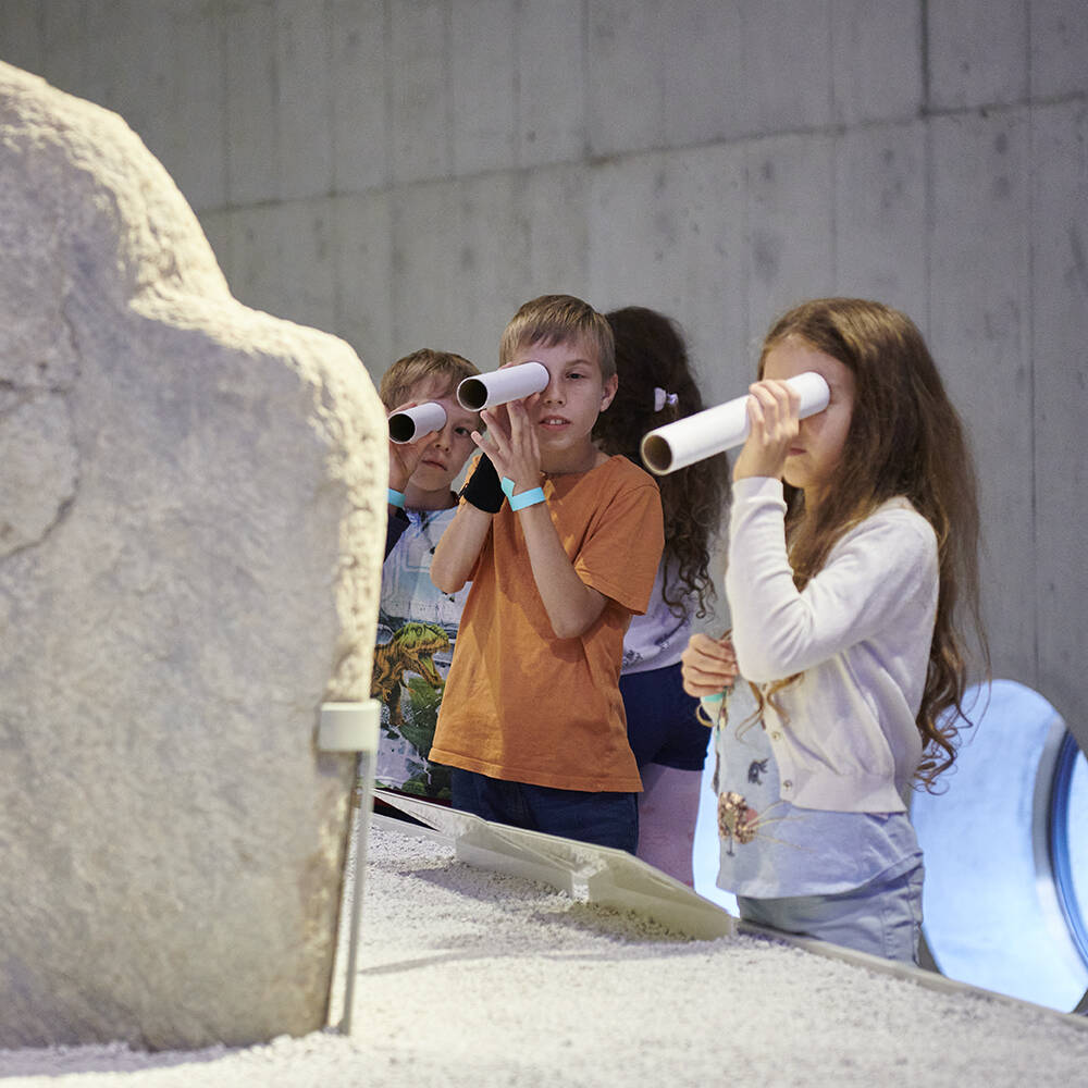 Kinder beim Entdecken der Objekte in der Wechselausstellung ""Menschen. In Stein gemeisselt".