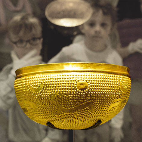 Children look at the gold bowl in the "Archaeology" exhibition