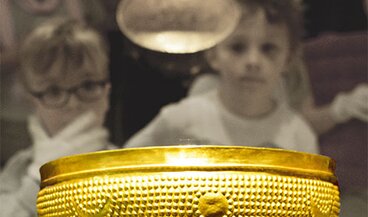I bambini osservano la coppa d'oro nella mostra "Archeologia".