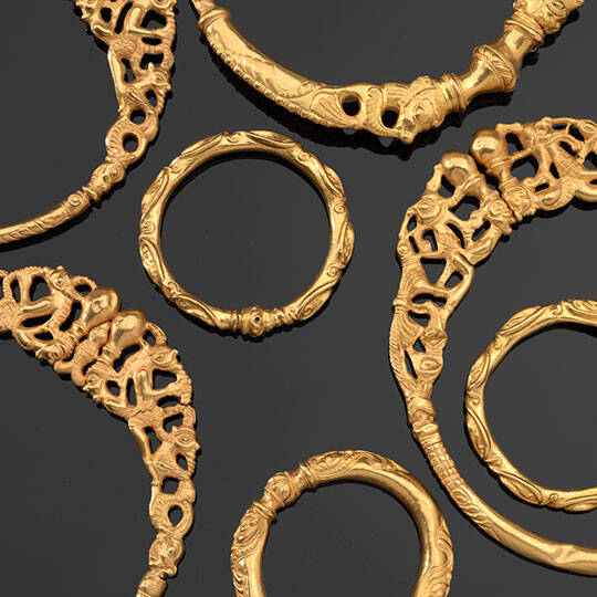 Picture of several neck rings made of gold.