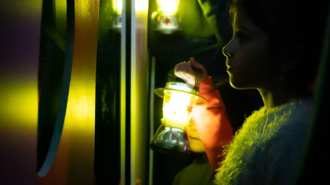 Enfants en route avec des lanternes pendant une visite guidée.