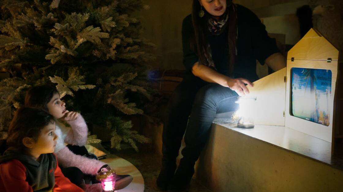 Kinder hören die Weihnachtsgeschichte im Advents-Atelier.