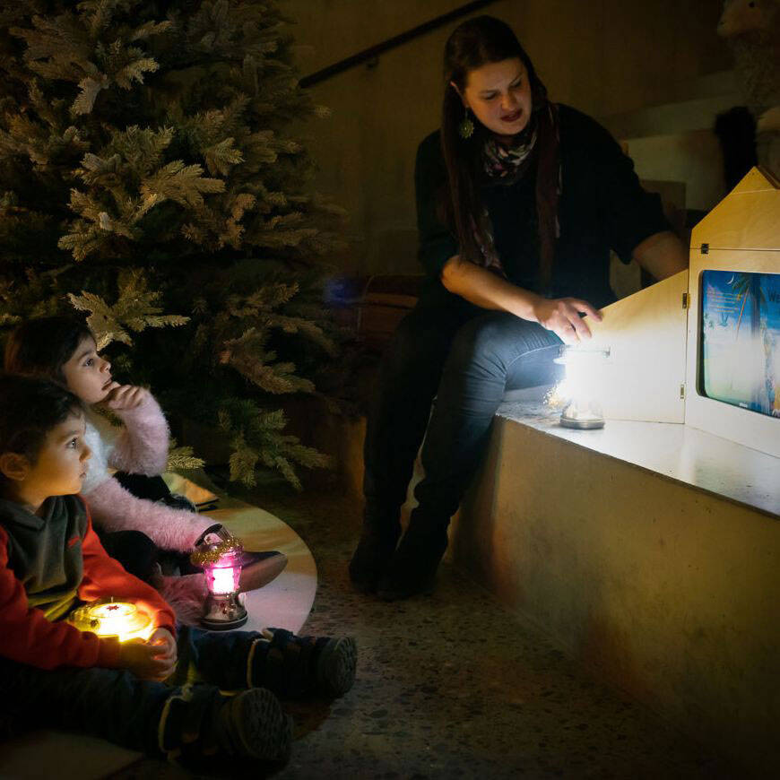 Kinder hören die Weihnachtsgeschichte im Advents-Atelier.