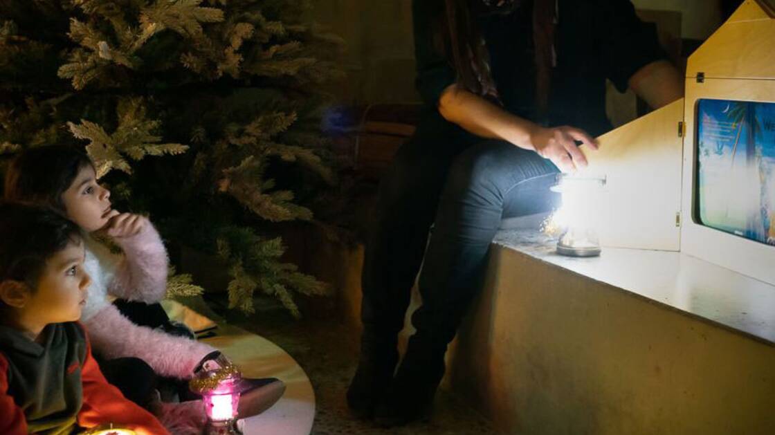 Kinder hören die Weihnachtsgeschichte im Advents-Atelier.
