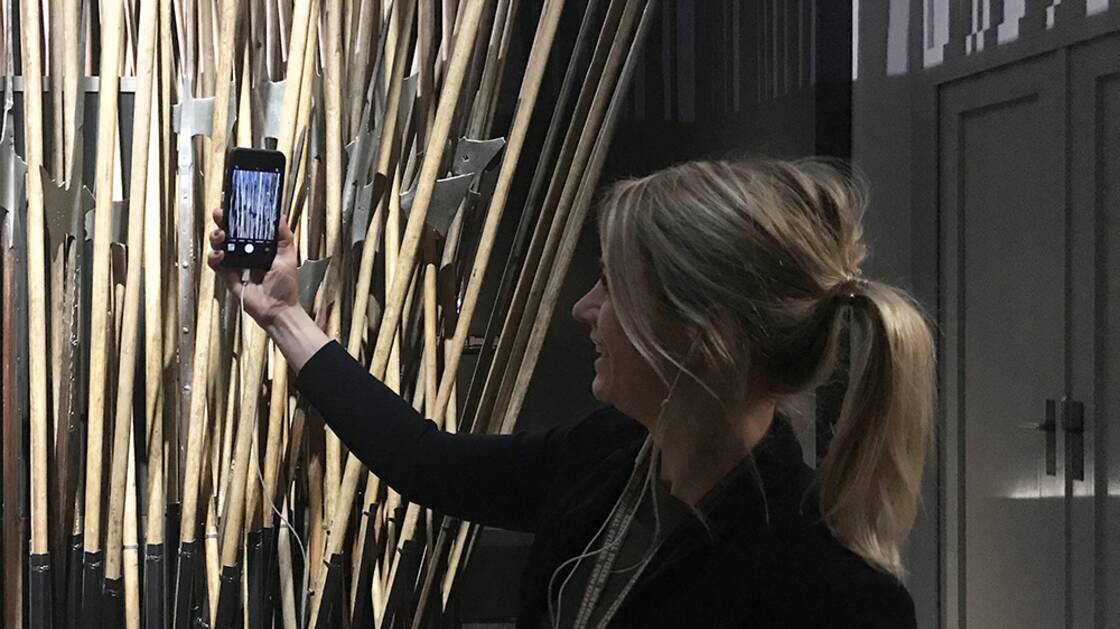 Vermittlungsperson mit iPhone während einer Virtuellen Führung.