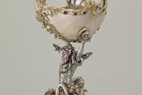 Pokal mit Triton, der einen Nautilus in den Händen hält. Kreation des Goldschmieds Johann Karl (Silvan) Bossard, in barockem Stil. Silber, teilvergoldet, mit Smaragden, Granat und Naturperlen. Um 1900.